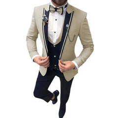 A man wears a beige three-piece suit with navy blue lapels, a matching vest, and dark trousers.