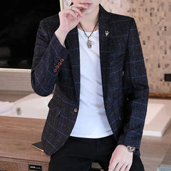 A man wears a slim-fit navy blue blazer with a subtle plaid pattern over a white t-shirt.