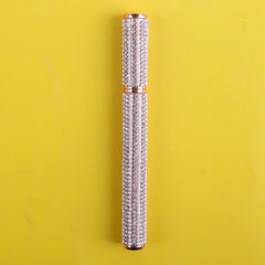An eyeliner pen decorated with rows of small white pearls and clear rhinestones.