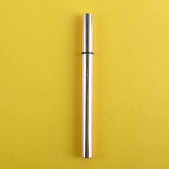 A sleek, gold-toned eyeliner pen stands vertically against a solid yellow background.