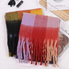 Two soft, thick cashmere scarves with colorful plaid patterns and long tassels.