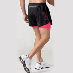 A man wears black two-in-one athletic shorts with a pink compression liner and white sneakers.