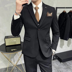 A man wears a black slim-fit three-piece suit with a white shirt and a brown tie.
