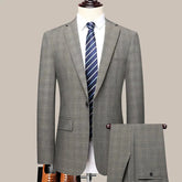 A grey checkered two-piece suit for men featuring a single-breasted blazer and matching trousers.