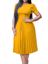 A woman wears a mustard yellow, short-sleeved, pleated midi dress with a high waist.
