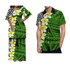 A woman in a green floral maxi dress and a man in a matching short-sleeved shirt.