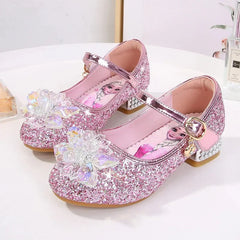 A pair of pink glittery children's princess shoes featuring Elsa graphics and crystal flower accents.