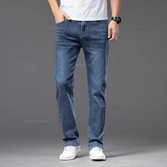 A man wears medium-wash straight-leg denim jeans with a classic five-pocket design.