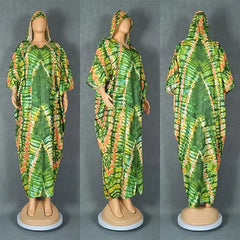 A green and orange tie-dye hooded kaftan dress with a loose, flowing silhouette.
