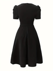 A black short-sleeved A-line dress with a fitted bodice and a simple back view.
