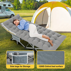 A grey folding camping cot with a padded surface, ergonomic headrest, and side storage pocket.