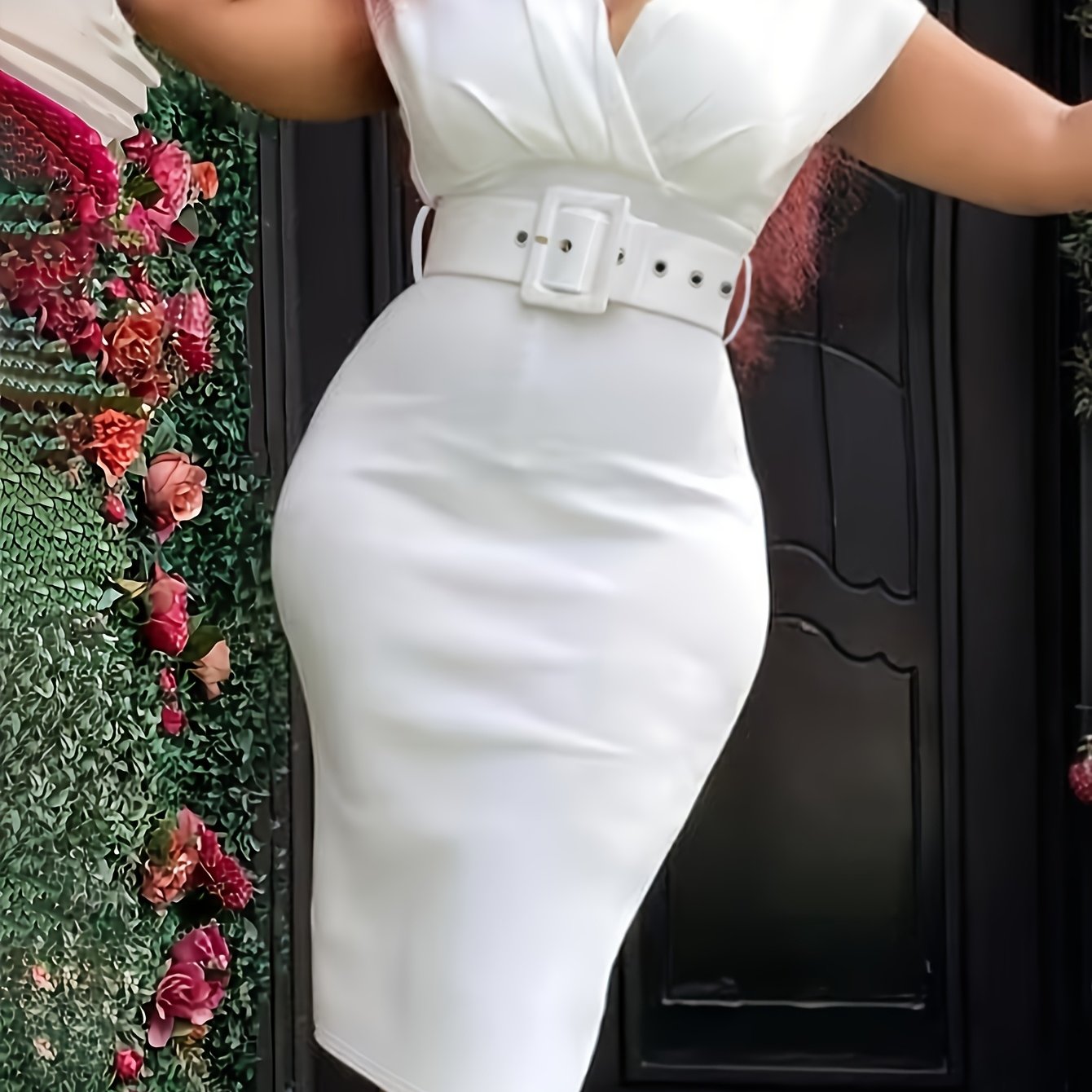 A woman wears a white V-neck bodycon dress featuring a matching belt and a pencil skirt silhouette.