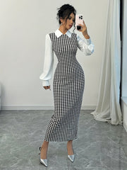 A woman wears a black and white houndstooth bodycon dress with a white collared top and puffed sleeves.