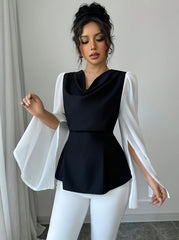 A woman wears a black cowl-neck top with long, split white sleeves and an asymmetrical hem.