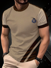 A men's beige crew neck t-shirt featuring a black polka dot pattern and brown contrast accents.