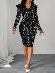 A woman wears a black and white polka dot bodycon dress with long sleeves and a ruffled side detail.