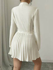 A person wears a white long-sleeved blazer with a matching pleated mini skirt from the back.