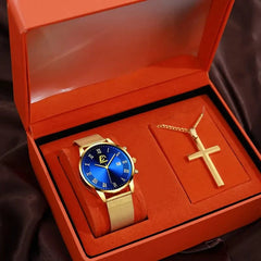 A gold-tone quartz watch with a blue dial and mesh strap paired with a cross necklace in a box.