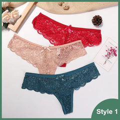 Three Sexy Lace Thong Panties (Style 1) from the 3 Pcs Woman Panties set are shown in red, beige, and teal on a flat surface with flowers, a pinecone, and a card nearby. Green label reads "Style 1.