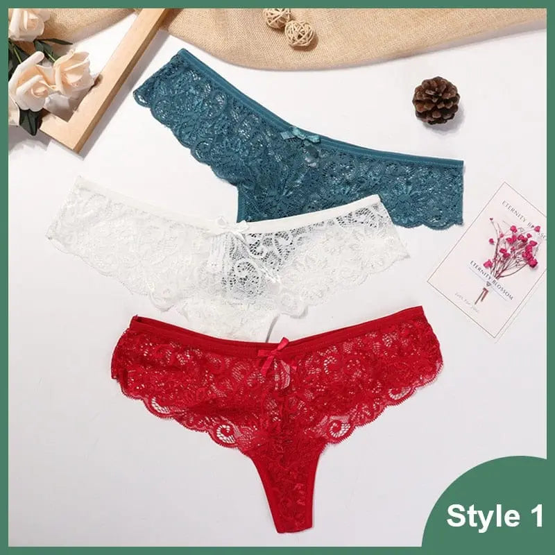 Three pairs of 3 Pcs Woman Panties Sexy Lace Thong Underwear are displayed in teal, white, and red on a white surface with flowers, a pinecone, and a card. The panties feature low waist and transparent lace T-back design. Text reads Style 1.