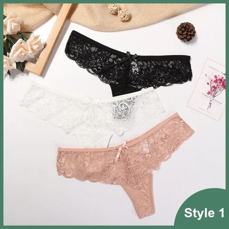 Three pairs of 3 Pcs Woman Panties Sexy Lace Thong Underwear are shown in black, white, and light pink on a white surface with flowers and decor. These low waist, transparent G-strings feature delicate lace for an elegant look; Style 1 is labeled.