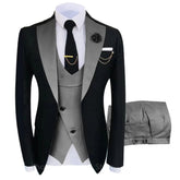 A three-piece men's suit featuring a black blazer with grey lapels, a grey vest, and matching trousers.