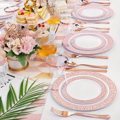 A table setting featuring white plastic plates with rose gold patterned rims and matching cutlery.
