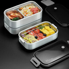 Two rectangular stainless steel bento lunch boxes with white plastic shells and black lids.