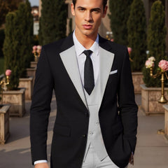 A man wears a black suit jacket with light gray lapels, a matching vest, and light gray pants.