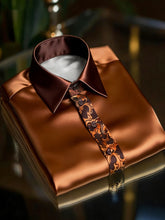 A brown satin button-up shirt with a dark brown collar and a patterned button placket.