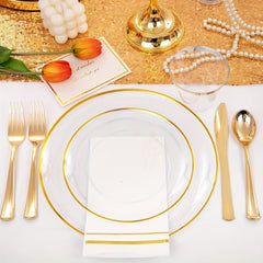 A clear and gold plastic dinnerware set featuring plates, cutlery, cups, and napkins.