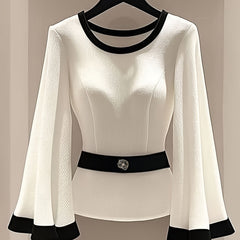 White long-sleeve blouse with black trim, flared sleeves, and a decorative belt.