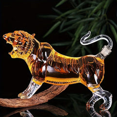 A glass tiger-shaped decanter filled with amber liquid, featuring a clear tail-shaped stopper.
