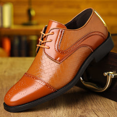 A tan, pointed-toe men's dress shoe with a plaid-textured upper and lace-up closure.