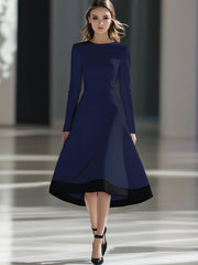 A woman wears a navy blue long-sleeve midi dress with a black hem and a cinched waist.