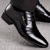 A pair of black lace-up dress shoes with a sleek, polished finish and decorative side detailing.