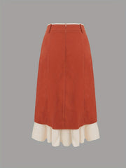 A high-waisted midi skirt in rust red with a contrasting white ruffled hem.