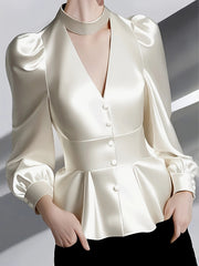 A cream-colored satin blouse featuring a halter neck, puff sleeves, and a cinched waist.