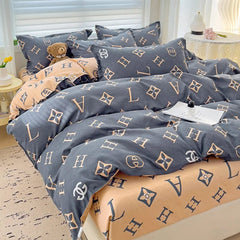 A four-piece cotton bedding set featuring a reversible design with dark grey and light tan letter patterns.
