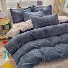 A four-piece cotton bedding set featuring a dark blue fabric with a yellow and white speckled print.