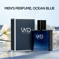 A bottle of Ocean Blue cologne for men stands next to its dark blue box on a reflective surface.