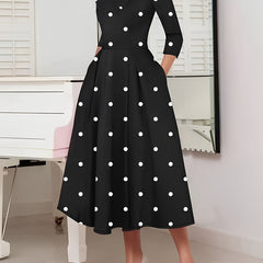 A black fit and flare dress featuring a white polka dot pattern, high neck, and three-quarter sleeves.