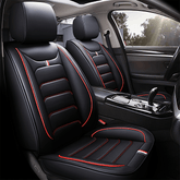 Black faux leather car seat covers with red piping and white striped accents.