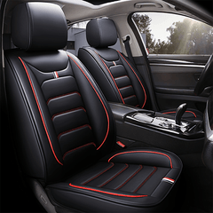 Black faux leather car seat covers with red piping and white striped accents.