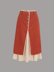 A high-waisted red midi skirt featuring a front button placket and a white layered hem.
