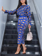 A woman wears a blue and tan plaid long-sleeved shirt and matching pants two-piece set.