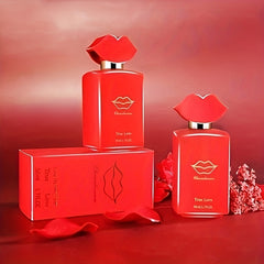 Two red perfume bottles with lip-shaped caps and matching boxes sit on a red surface.