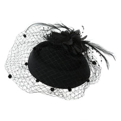 A black pillbox fascinator hat adorned with a flower, feathers, and a beaded mesh veil.