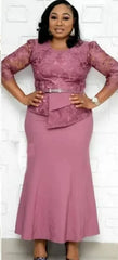 A woman wears a dusty rose ankle-length maxi dress featuring lace sleeves and a belted waist.