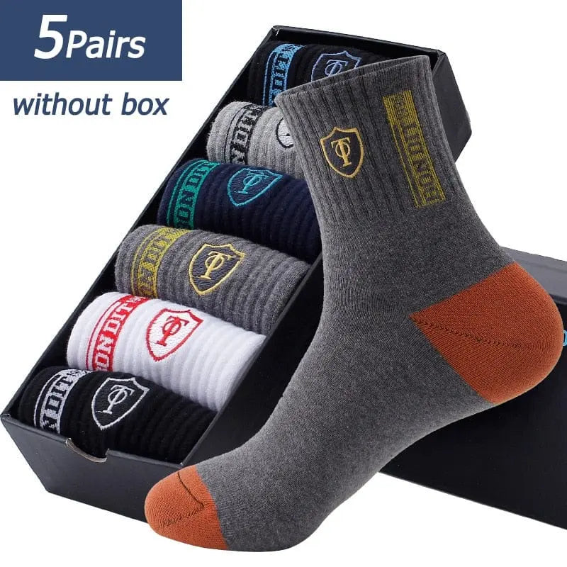 The 5 Pairs Spring and Fall Men's Sports Socks set features thin, breathable, sweat-absorbent cotton socks in assorted colors with contrast toes and heels, EU 38-43, displayed in a black box. One gray and orange sock is shown in front for detail.